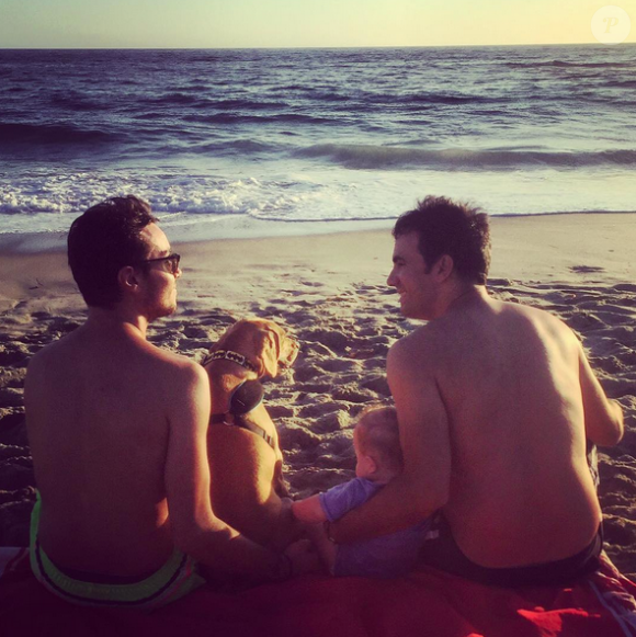 Alex Goude, son mari Romain, leur fils Elliot et leur chien au bord de la plage. Août 2015.