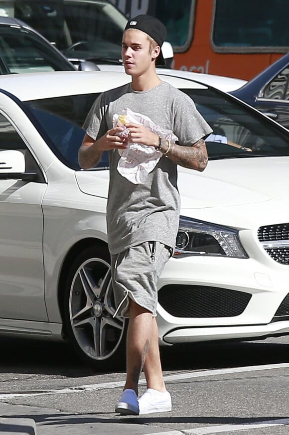 Exclusif - Justin Bieber mange un sandwich alors qu'il retourne au Montage Beverly Hills Hotel à Beverly Hills, le 15 août 2015. Le chanteur a refusé de signer des autographes et de faire des photos avec ses fans car il ne voulait pas être dérangé pendant qu'il mangeait.