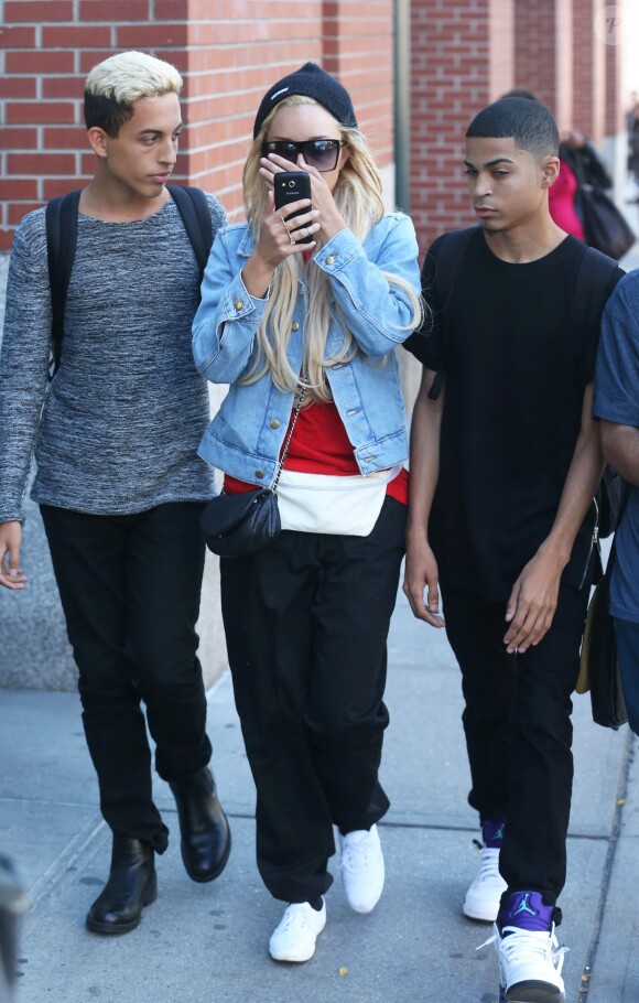 Amanda Bynes (sac Chanel) se cache le visage avec son téléphone portable alors qu'elle se promène avec des amis dans les rues de New York. Le 6 octobre 2014