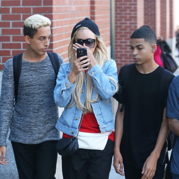 Amanda Bynes (sac Chanel) se cache le visage avec son téléphone portable alors qu'elle se promène avec des amis dans les rues de New York. Le 6 octobre 2014