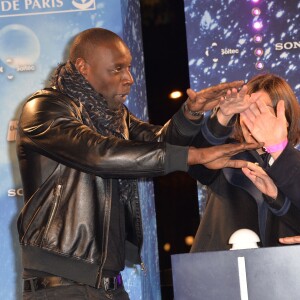 Omar Sy, en présence de la maire de Paris Anne Hidalgo, assure le coup d'envoi des illuminations sur l'avenue des Champs-Élysées à Paris le 20 novembre 2014.