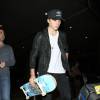 Brooklyn Beckham, armé de son skateboard, arrive à l'aéroport de Los Angeles le 23 octobre 2015.
