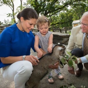 La princesse Estelle de Suède photographiée avec sa maman la princesse Victoria et son papy le roi Carl XVI Gustaf à l'été 2014 à Skansen par Kate Gabor.