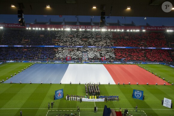 Un drapeau tricolore immense déployé sur la pelouse du Parc des Princes, avant le coup d'envoi du match Paris Saint-Germain (PSG)-Troyes à Paris, le 28 novembre 2015, lors de la minute de silence des joueurs et de spectateurs en hommage aux victimes des attentats du 13 novembre.