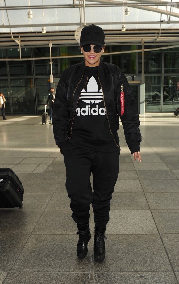Rita Ora arrive à l'aéroport Heathrow, habillée d'un pull et d'un jogging adidas Originals. Une casquette Supreme, un bomber Alpha Industries et des bottes Louis Vuitton complètent sa tenue entièrement noire. Londres, le 13 novembre 2015.