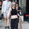 Dakota Fanning à New York, porte un crop top noir, un jogging et des baskets adidas Originals (modèle Stan Smith). Le 26 juin 2015.