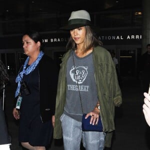 Jessica Alba arrive à l'aéroport de Los Angeles en provenance de Paris, habillée d'une veste kaki Rebecca Minkoff, d'un pull gris The Great, d'un jogging Bella Dahl assorti et de chaussures blanches. Un chapeau Maison Michel, un sac Chanel et une valise Louis Vuitton accessoirisent sa tenue. Le 9 juillet 2015.