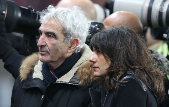 Raymond Domenech et sa compagne Estelle Denis lors du match de Ligue 1 PSG-Lyon lors de la 18e journée au Parc des Princes à Paris, le 13 décembre 2015.