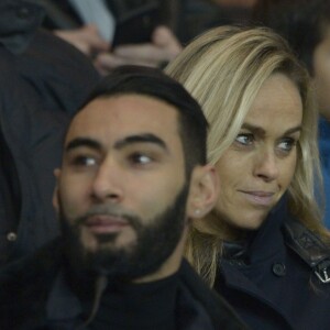 La Fouine et Cécile de Ménibus lors du match de Ligue 1 PSG-Lyon lors de la 18e journée au Parc des Princes à Paris, le 13 décembre 2015.