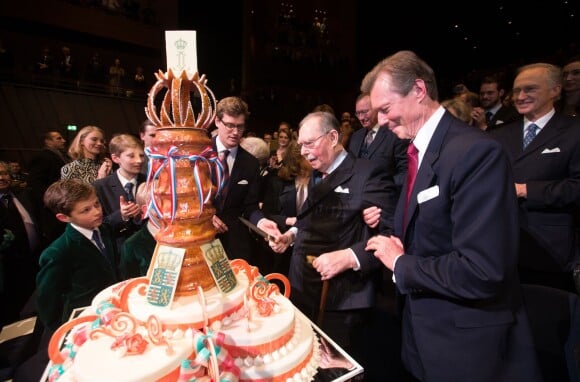 Le grand-duc Jean de Luxembourg, avec à ses côtés son fils le grand-duc Henri, coupe le gâteau d'anniversaire pour ses 95 ans lors d'une soirée de gala à la Philharmonie de Luxembourg le 9 janvier 2016.