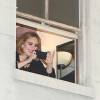 Adele dit bonjour à ses fans depuis sa fenêtre avant son concert au Wiltern Theatre à Los Angeles, le 12 février 2016