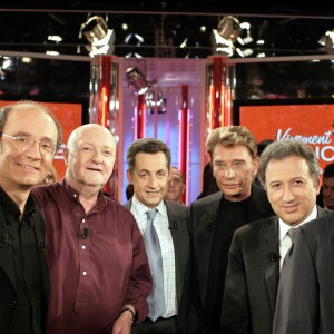 Philippe Geluck et Jean-Pierre Coffe entourés de Nicolas Canteloup, Nicolas Sarkozy, Johnny Hallyday, Michel Drucker et Jean-Pierre Elkabbach dans Vivement Dimanche en 2004.