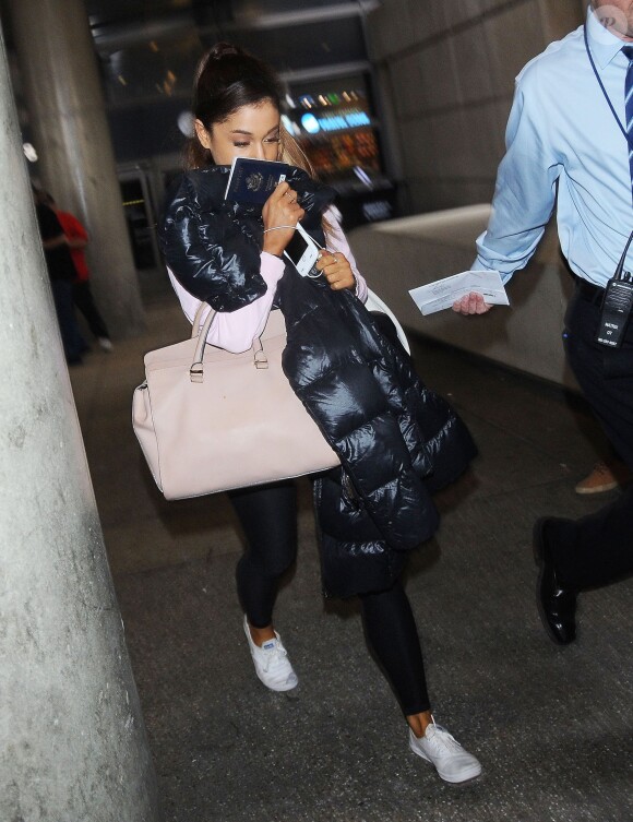 Ariana Grande se cache des photographes à son arrivée à l'aéroport de LAX à Los Angeles, le 3 juillet 2015 Singer Ariana Grande arriving on a flight at LAX airport in Los Angeles, California on July 3, 201503/07/2015 - Los Angeles