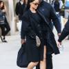 Rihanna se rend au Barclays Center à Brooklyn, habillée d'un manteau et d'une robe noirs, et chaussée de sandales Christian Dior (prêt-à-porter printemps-été 2016). Le 30 mars 2016.