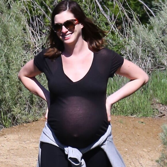 Anne Hathaway, enceinte, se promène avec son mari Adam Shulman et ses chiens à Los Angeles le 12 Mars 2016.