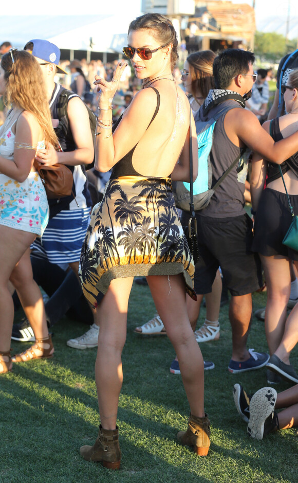 Alessandra Ambrosio assiste au Week-end 1, Jour 2 du festival Coachella, habillée d'un body noir, d'un blouson et de bottines Saint Laurent par Hedi Slimane noué à la taille, et d'un mini-short RE/DONE. Le top model porte également un sac Chloé (modèle Hudson). Le 16 avril 2016.