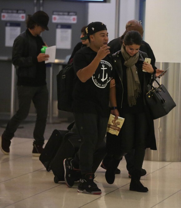 Exclusif - Orlando Bloom avec un chapeau et Selena Gomez (sac Prada modèle Saffiano) quittent l'aéroport de LAX à Los Angeles, le 20 octobre 2014
