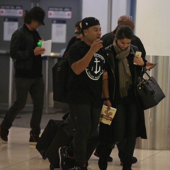 Exclusif - Orlando Bloom avec un chapeau et Selena Gomez (sac Prada modèle Saffiano) quittent l'aéroport de LAX à Los Angeles, le 20 octobre 2014