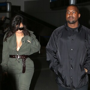 Kim Kardashian portant un décolleté très généreux, et son mari Kanye West arrivent à l'aéroport de Los Angeles (LAX), le 24 mai 2016.