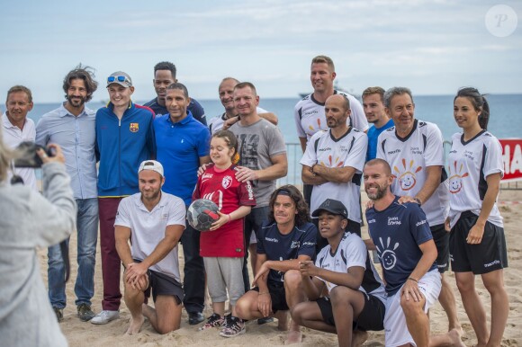 François Feldman (à droite) entouré de footballeurs lors du match de gala du 2e Beach Soccer à Cannes au profit de l'association Sourire et Partage, sur la plage Macé le 1er juin 2016