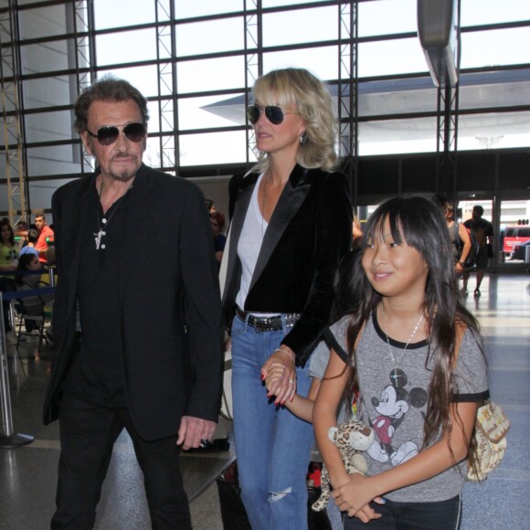 Johnny Hallyday avec sa femme Laeticia et ses enfants Jade et Joy en partance pour Paris arrivent à l'aéroport Lax de Los Angeles le 25 juin 2016.