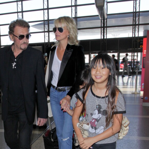 Johnny Hallyday avec sa femme Laeticia et ses enfants Jade et Joy en partance pour Paris arrivent à l'aéroport Lax de Los Angeles le 25 juin 2016.