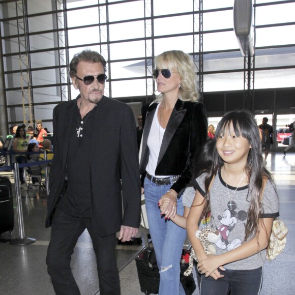 Johnny Hallyday avec sa femme Laeticia et ses enfants Jade et Joy en partance pour Paris arrivent à l'aéroport Lax de Los Angeles le 25 juin 2016.