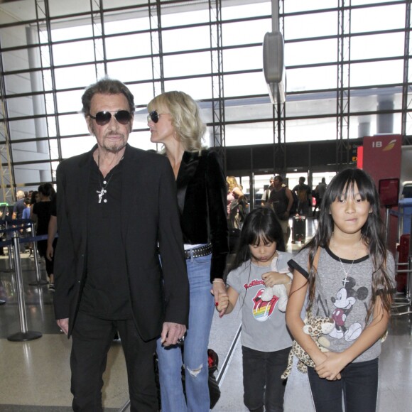 Johnny Hallyday avec sa femme Laeticia et ses enfants Jade et Joy en partance pour Paris arrivent à l'aéroport Lax de Los Angeles le 25 juin 2016.