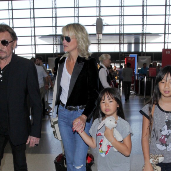 Johnny Hallyday avec sa femme Laeticia et ses enfants Jade et Joy en partance pour Paris arrivent à l'aéroport Lax de Los Angeles le 25 juin 2016.