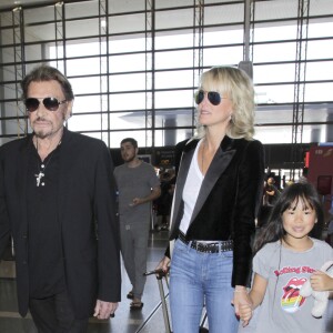 Johnny Hallyday avec sa femme Laeticia et ses enfants Jade et Joy en partance pour Paris arrivent à l'aéroport Lax de Los Angeles le 25 juin 2016.