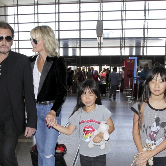 Johnny Hallyday avec sa femme Laeticia et ses enfants Jade et Joy en partance pour Paris arrivent à l'aéroport Lax de Los Angeles le 25 juin 2016.