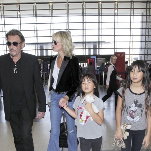 Johnny Hallyday avec sa femme Laeticia et ses enfants Jade et Joy en partance pour Paris arrivent à l'aéroport Lax de Los Angeles le 25 juin 2016.