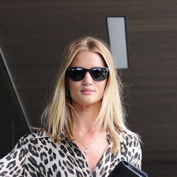 Rosie Huntington-Whiteley arrive au QG de la marque PAIGE® à West Hollywood, habillée d'un chemisier léopard L'Agence, d'un jean PAIGE® et de sandales Gianvito Rossi. Des lunettes Ray-Ban et une pochette Saint Laurent accessoirisent sa tenue. Le 27 juin 2016.