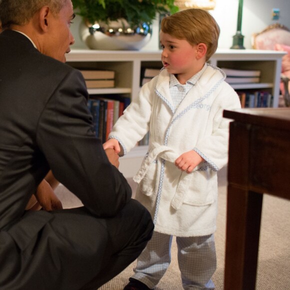 Le prince George de Cambridge salue le président américain Barack Obama et sa femme Michelle Obama avant d'aller se coucher lors de leur venue à Kensington Palace à Londres, le 22 avril 2016.