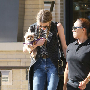 Exclusif - Amber Heard avec son petit chien dans les bras et accompagnée d'un garde du corps, sort de la boutique "Barneys New York" à Beverly Hills. Los Angeles, le 12 juillet 2016.