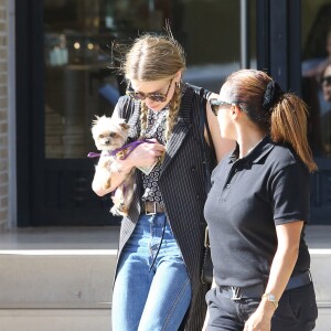 Exclusif - Amber Heard avec son petit chien dans les bras et accompagnée d'un garde du corps, sort de la boutique "Barneys New York" à Beverly Hills. Los Angeles, le 12 juillet 2016.