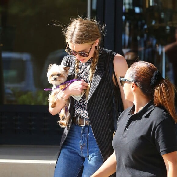 Exclusif - Amber Heard avec son petit chien dans les bras et accompagnée d'un garde du corps, sort de la boutique "Barneys New York" à Beverly Hills. Los Angeles, le 12 juillet 2016.