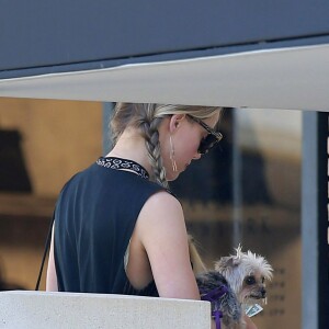 Exclusif - Amber Heard avec son petit chien dans les bras et accompagnée d'un garde du corps, sort de la boutique "Barneys New York" à Beverly Hills. Los Angeles, le 12 juillet 2016.