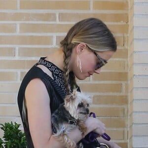 Exclusif - Amber Heard avec son petit chien dans les bras et accompagnée d'un garde du corps, sort de la boutique "Barneys New York" à Beverly Hills. Los Angeles, le 12 juillet 2016.