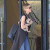Exclusif - Amber Heard avec son petit chien dans les bras et accompagnée d'un garde du corps, sort de la boutique "Barneys New York" à Beverly Hills. Los Angeles, le 12 juillet 2016.