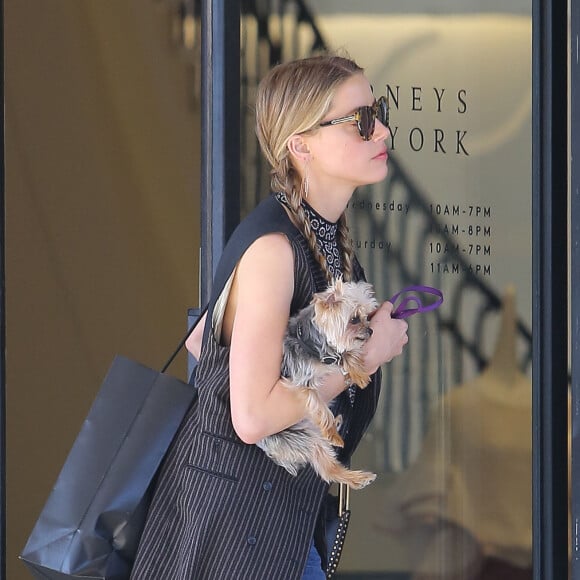 Exclusif - Amber Heard avec son petit chien dans les bras et accompagnée d'un garde du corps, sort de la boutique "Barneys New York" à Beverly Hills. Los Angeles, le 12 juillet 2016.