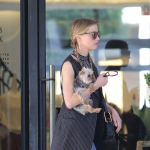 Exclusif - Amber Heard avec son petit chien dans les bras et accompagnée d'un garde du corps, sort de la boutique "Barneys New York" à Beverly Hills. Los Angeles, le 12 juillet 2016.