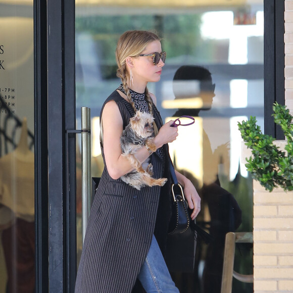 Exclusif - Amber Heard avec son petit chien dans les bras et accompagnée d'un garde du corps, sort de la boutique "Barneys New York" à Beverly Hills. Los Angeles, le 12 juillet 2016.
