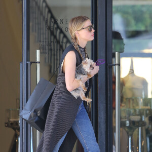 Exclusif - Amber Heard avec son petit chien dans les bras et accompagnée d'un garde du corps, sort de la boutique "Barneys New York" à Beverly Hills. Los Angeles, le 12 juillet 2016.