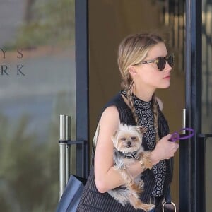 Exclusif - Amber Heard avec son petit chien dans les bras et accompagnée d'un garde du corps, sort de la boutique "Barneys New York" à Beverly Hills. Los Angeles, le 12 juillet 2016.