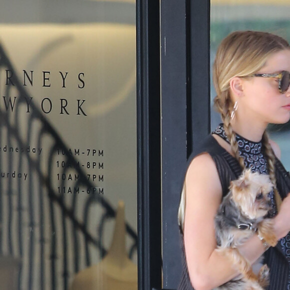 Exclusif - Amber Heard avec son petit chien dans les bras et accompagnée d'un garde du corps, sort de la boutique "Barneys New York" à Beverly Hills. Los Angeles, le 12 juillet 2016.