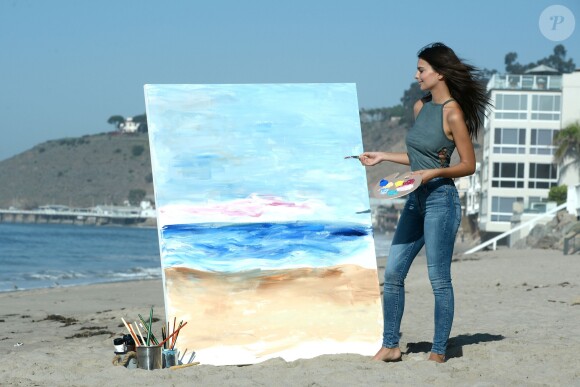 Emily Ratajkowski fait de la peinture sur la plage de Malibu, habillée d'un haut et d'un jean American Eagle. Los Angeles, le 16 août 2016.