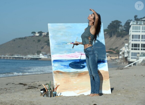 Emily Ratajkowski fait de la peinture sur la plage de Malibu, habillée d'un haut et d'un jean American Eagle. Los Angeles, le 16 août 2016.