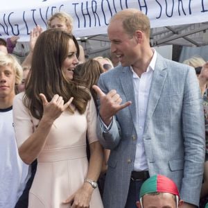 Le duc et la duchesse de Cambridge font le signe de Shaka, comme de vrais riders. Kate Middleton et le prince William ont achevé leur journée d'activités publiques en Cornouailles, le 1er septembre 2016, sur la plage Towan, à Newquay, à l'occasion d'une session d'initiation au surf organisée par l'association Wave Project.