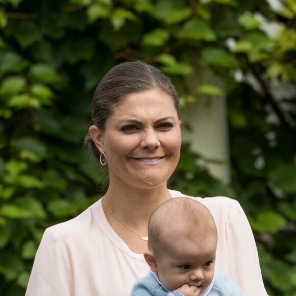 La princesse Victoria de Suède, ici avec son fils le prince Oscar dans les bras le 15 juillet 2016, a été désignée marraine de son neveu le prince Alexander, baptisé le 9 septembre 2016.